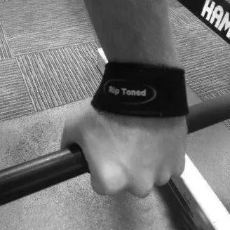 Black Rip Toned lifting straps beside dumbbells
