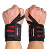 Two hands wearing Rip Toned Wrist Wraps: Stiff and Flex in red, straps wrapped around wrists and thumbs for powerlifter-level support during weightlifting or heavy lifts.